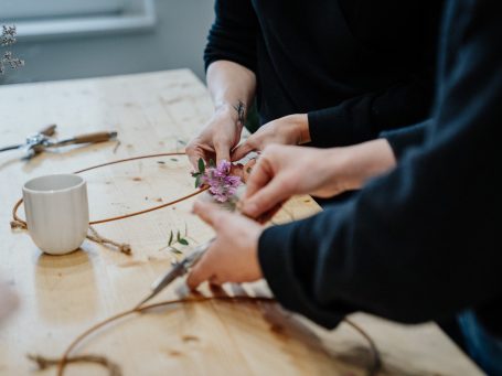 Grüne Kranzdekoration mit Eukalyptus und kleinen Beeren auf einem Holztisch.