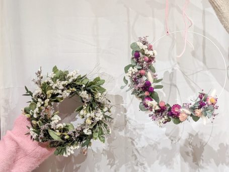 Adventskranz Grüne Kranzdekoration mit Eukalyptus und kleinen Beeren auf einem Holztisch.