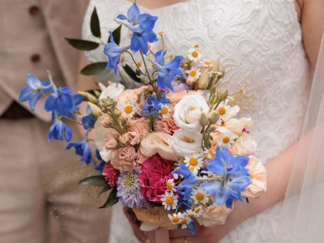 Brautstrauß Bunter Brautstrauß mit lila, rosa und weißen Blüten auf einem holzigen Untergrund.